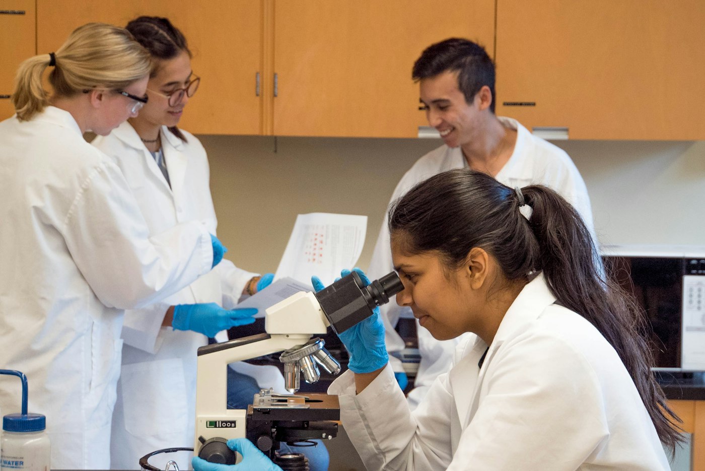 Scientists working together at a microscope